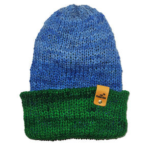 Blue and green knit beanie with a brand tag on a white background